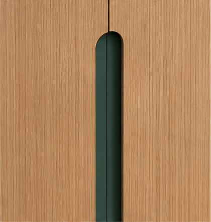 Détail de la prise de doigt verticale entre deux portes en chêne, une fente au sommet arrondi laissant apparaître un fond vert profond.