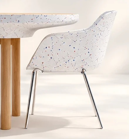 Vue de côté d'une chaise coque placée contre la table, dont le profil du pourtour répond à la courbe du dossier.